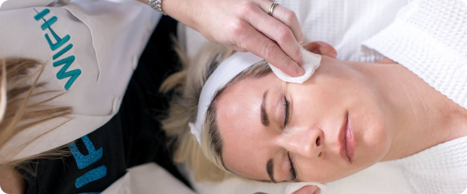 An aesthetic provider gently cleansing a patient's face before a skin rejuvenation procedure